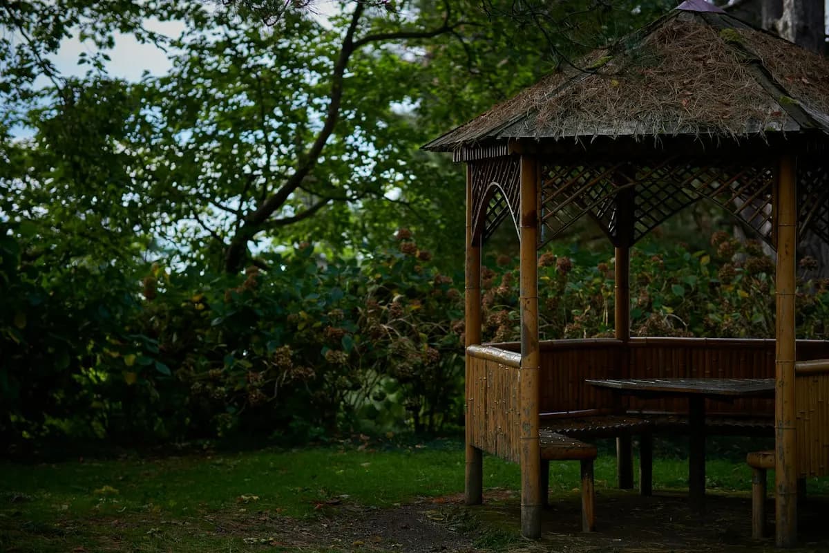 Timber gazebo with built-in seating under a pitched roof