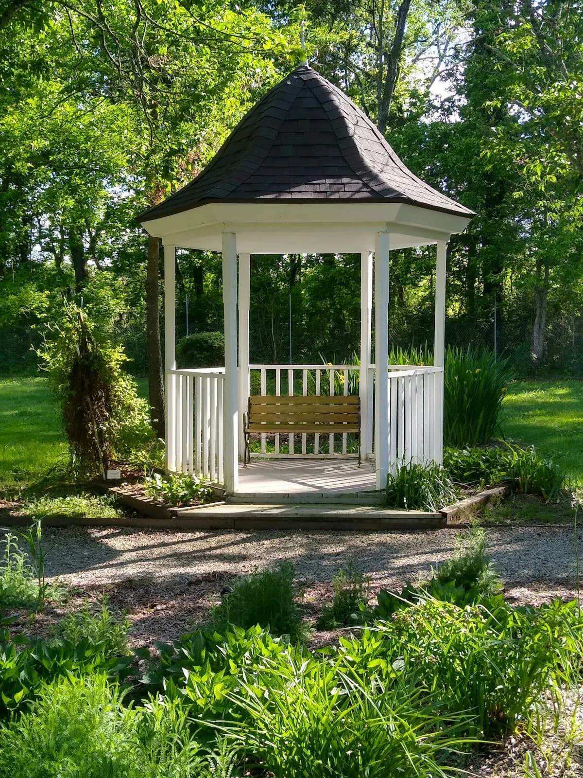 Small white garden gazebo beside a path